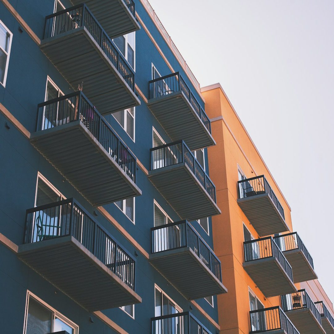 Apartments Colorful apartment building with modern balconies against a clear sky.